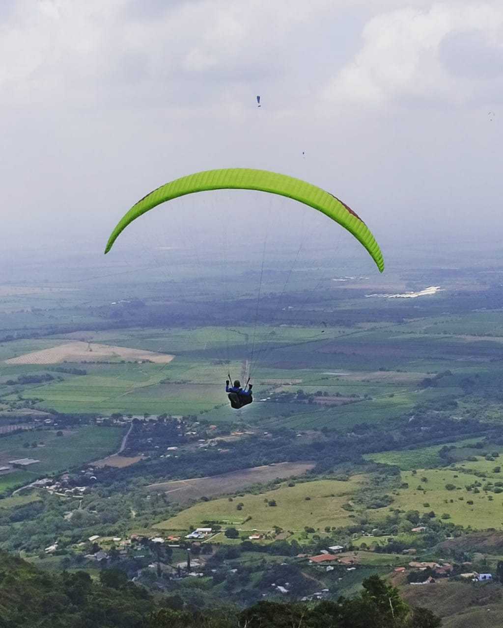 Marc Pelberg paragliding high above a valley